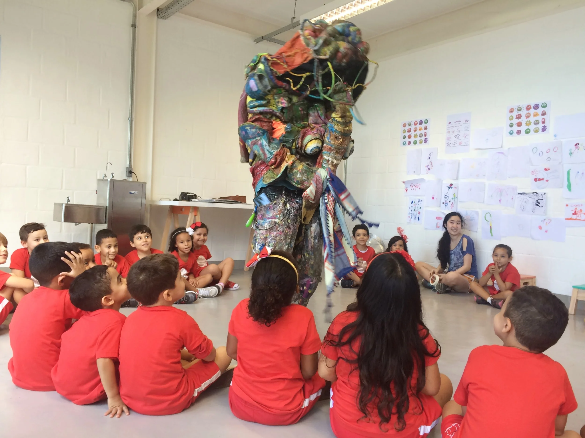 Children gathered around a colorful performance during outreach