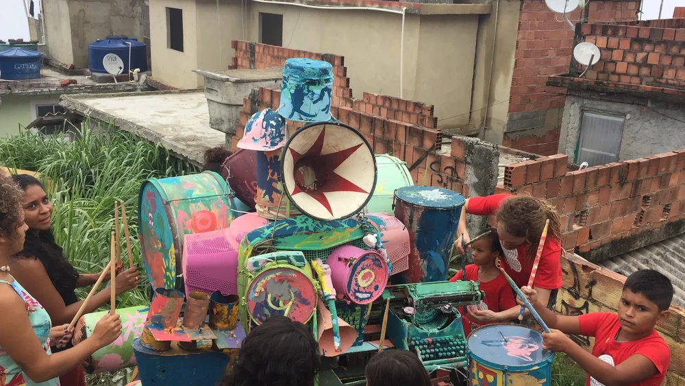 Students gathered around a colorful community art machine outdoors